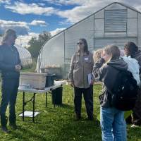 The farm manager along with a professor speak about the SAP's compost usage to a group of interested students and community members.